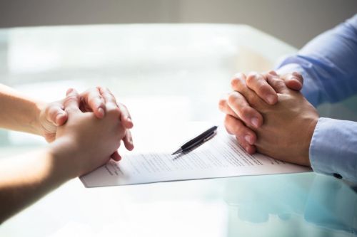 couple sitting across from each other with hands folded