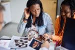 same-sex couple looking at sonograms at doctor's office - assisted reproductive technology concept