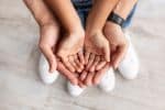 Cropped close up above top view of man holding girl's palms in hands - Parents health child custody concept
