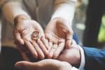 couple both holding their wedding rings in their hands together - what is collaborative divorce concept
