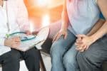 A couple holding hands speaking with a fertility doctor