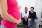 Pregnant surrogate mother with married couple